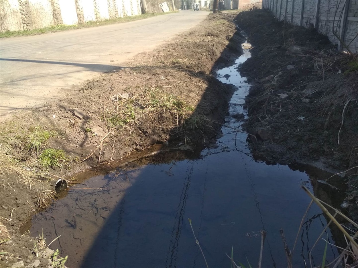 Через трубу вода течет под дорогой