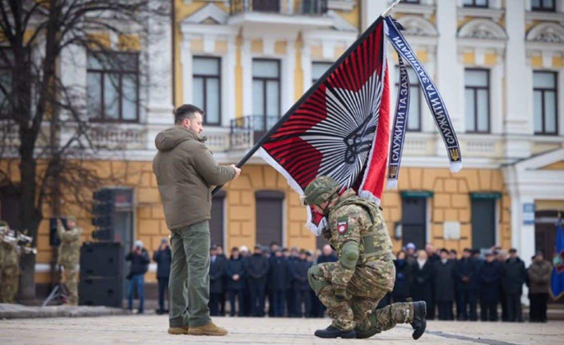 Президент України Володимир Зеленський вручає бойовий прапор командиру бригади "Лють" Олександру Нетребку. 
Київ, 24 лютого 2023 року